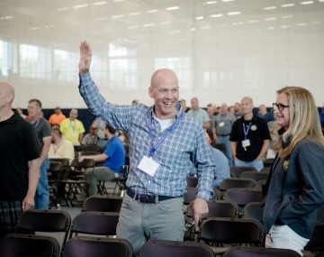 A Man holding his hand in the air, and a women looking at the presentation 